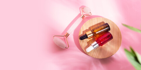 Top view of cosmetics face roller and droppers with oil.Self care concept,large banner.