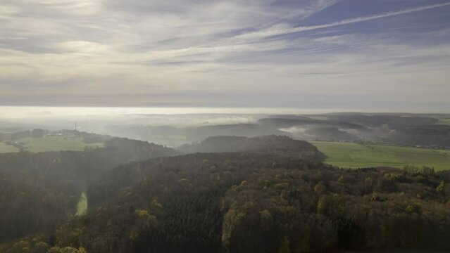 Landscape of Swabian Jura with forests and fog on a morning in autumn aerial time lapse
