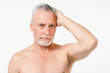 Obraz premium Handsome caucasian mature middle-aged senior naked man with grey hair and beard showing muscles for skin care isolated in white background. Male beauty concept