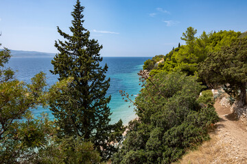 Fototapeta na wymiar Beautiful landscape of adriatic sea and Brac island shore in the summer with pine trees creating shades above turquoise sea and pebble beaches