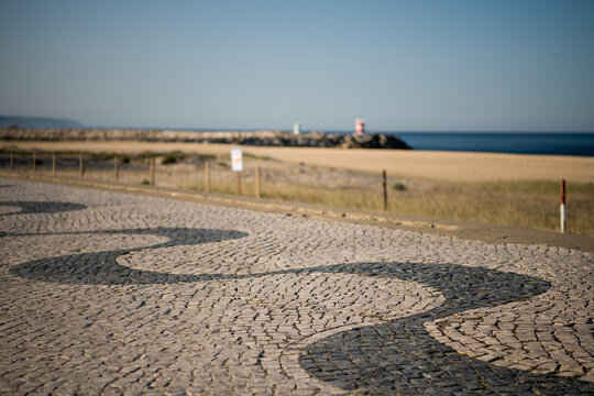 Mosaic sidewalk with pier in distance