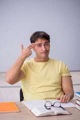Young male student sitting in the classroom