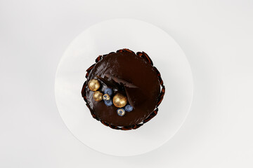 chocolate cake decorated with gold and berries