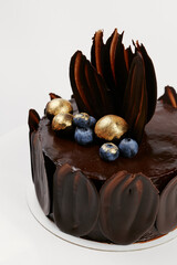 chocolate cake decorated with gold and berries