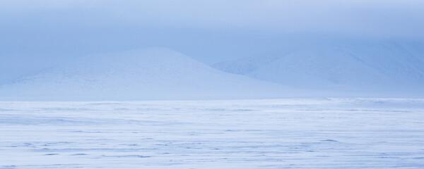 Winter arctic landscape. View of the snow-covered tundra and mountains. Panorama of the snowy...