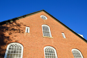 Red brick Moravian style church architecture with blue sky in the background