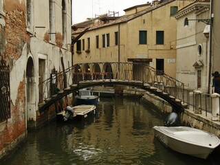 Bridge over a narrow canal sidelined by old buildings in Venice, Italy
