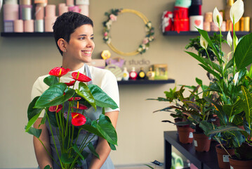 Fototapeta premium Young woman professional florist working with flowers in her flower shop 