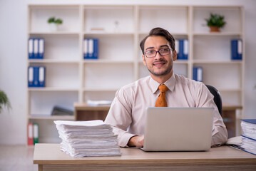 Young male employee and too much work in the office