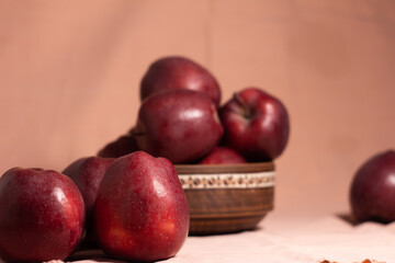 Delicious juicy red apples on the background of a blurred clay plate with apples