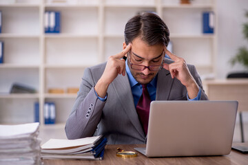 Fototapeta premium Young male employee working in the office