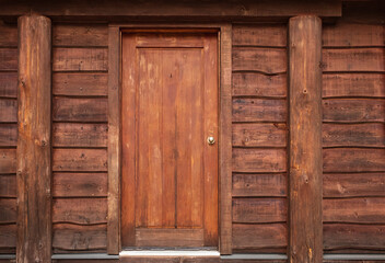 Houten voordeur naar rustieke hut. Houten muur met oude deur. Rustieke blokhut met voordeur in het bos BC.