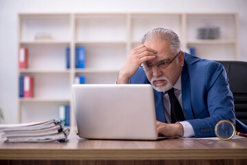 Old male employee working in the office