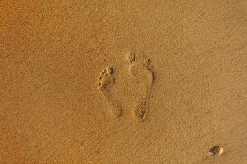 Fototapeta na wymiar father and son steps on a sand