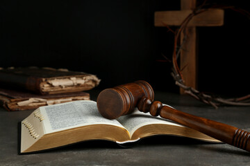 Judge gavel, bible, wooden cross and crown of thorns on grey table