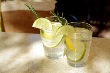 Glasses of tasty refreshing lemonade on light table, space for text. Summer drink