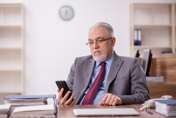 Naklejka premium Old male boss employee working in the office