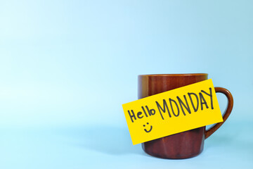 Welcome, hello and happy Monday concept. Selective focus of coffee cup with bright yellow paper...
