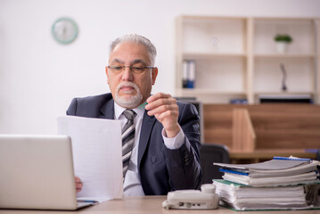 Fototapeta premium Old male boss employee working in the office