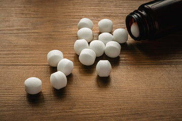 Naphthalene mothballs on wooden background.