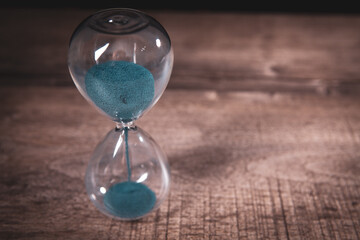 A side view of an hourglass with falling sand,