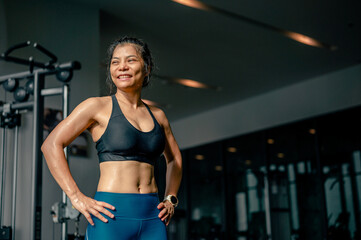 Smiley asian woman fit stand with confidence after abs abdomen cardio workout exercise in fitness....