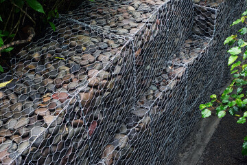 Gabion retaining wall filled with stones in a forest