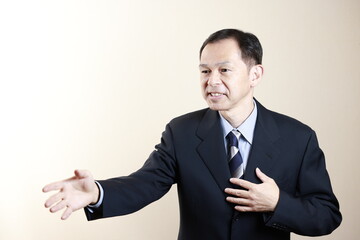 Middle-aged Japanese male businessman wearing navy blue suit on white background. Conceptual image of a project proposal, strategic business success and negotiation closing.