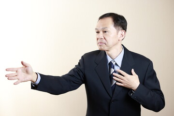 Middle-aged Japanese male businessman wearing navy blue suit on white background. Conceptual image of a project proposal, strategic business success and negotiation closing.