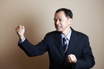 Middle-aged Japanese male businessman wearing navy blue suit on white background. Conceptual image of a project proposal, strategic business success and negotiation closing.
