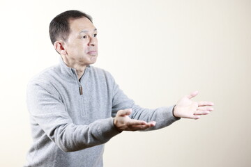 Middle-aged Japanese man in gray turtleneck wool sweater under white background. Concept image of Warm Biz, stability in daily life, and sustainable living.