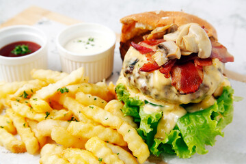 Freshly made hamburger with bacon sandwich and french fries