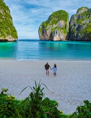Thai women and caucasian men walk on the beach of Maya Bay beach Koh Phi Phi Thailand in the...
