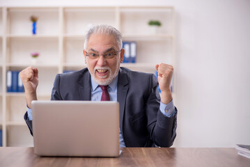 Old male boss employee working in the office