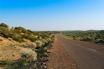 Morning in desert with empty high road or national high way passing through the desert. Distant horizon, Hot summer at Thar desert, Rajasthan, India.