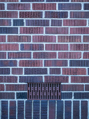 background texture of a brick wall with red colour and a vent hole - 548386065