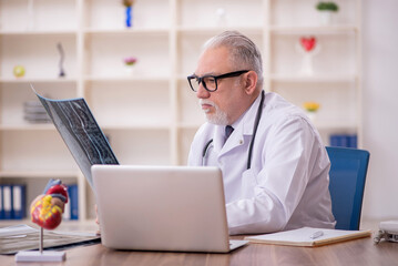 Old male doctor radiologist working in the clinic