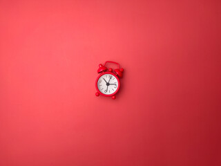 Top view red alarm clock on a red background. Background and texture concept.