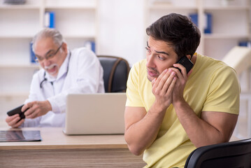 Young male patient visiting old male doctor