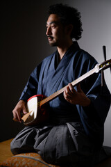 Cool middle-aged Japanese man playing the shamisen Japanese culture