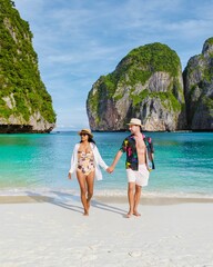 Thai women and caucasian men walking out of the ocean on the beach of Maya Bay beach Koh Phi Phi Thailand © Fokke Baarssen