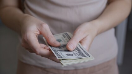 Close-up shot, men's hands are counting one hundred dollar banknotes. The man is filled with pleasant excitement from the memories of yesterday's winnings at the casino