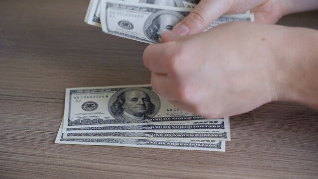 Close-up Of Male Hands Counting Paper Money. The Man Is Afraid To Remain Unemployed And Thinks Where To Invest The Dollars That He Was Able To Accumulate