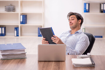 Young male employee and too much work in the office