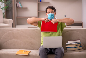 Young male student preparing for exams at home during pandemic