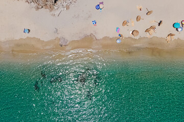 Fototapeta na wymiar Drone aerial view of the beach on greek island Mykonos. Umbrellas and unrecognizable people