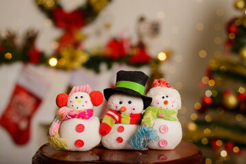 Snowmen made of wool and yarn with Christmas background. Decorative crafts for Christmas.