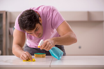 Young male contractor cleaning the house