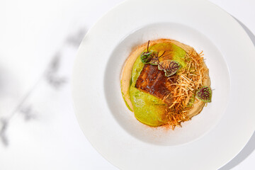 Roasted fish with crispy skin, celery cream and fresh herbs espuma. Fried halibut fillet on mashed...