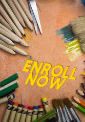 Overhead shot of school supplies with Enroll Now text. Brushes, pencils, artistic tools. Art And...
